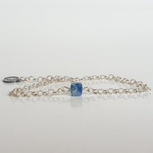 Load image into Gallery viewer, A silver bracelet featuring a faceted cube-shaped kyanite bead and a medallion made of 925 silver, on a white background.