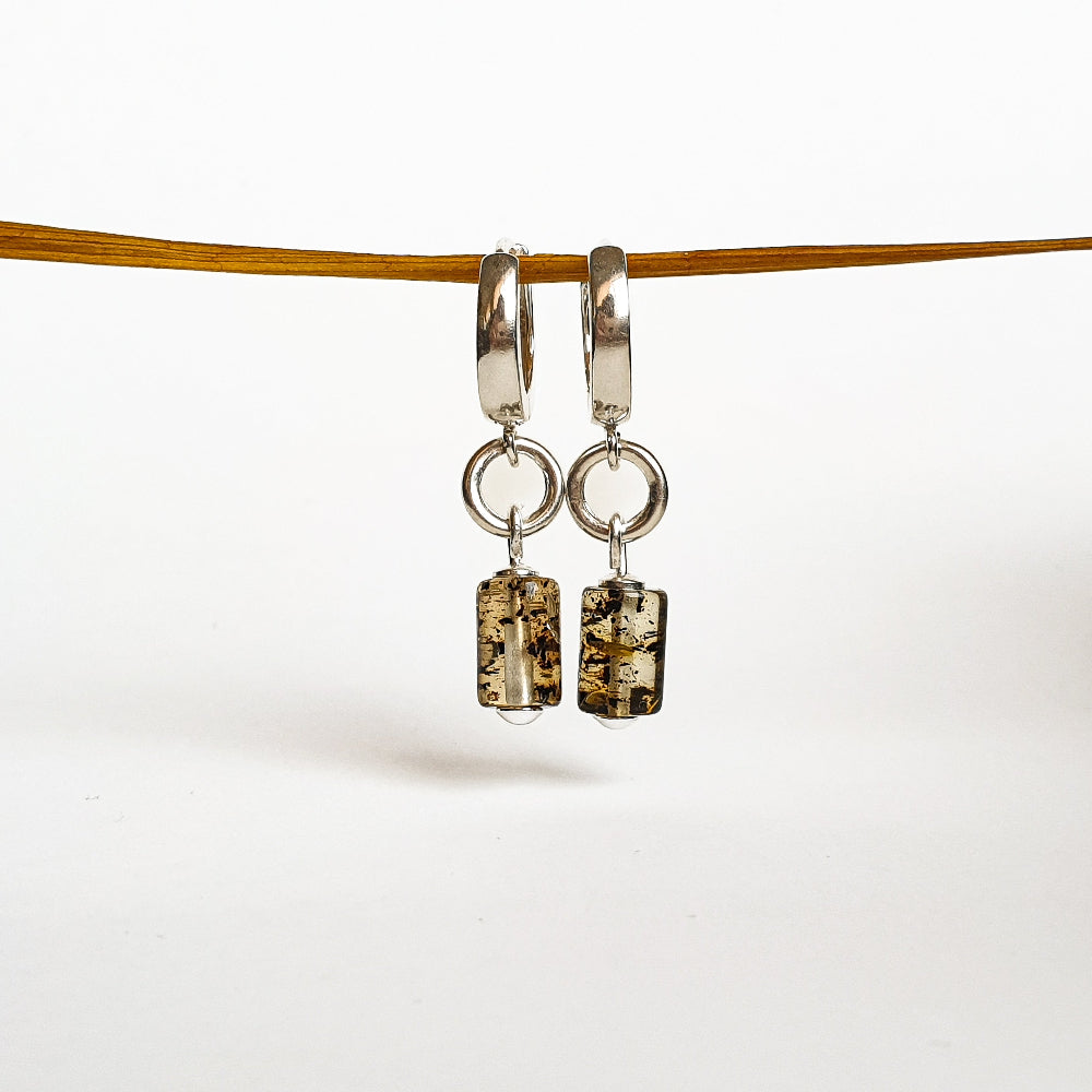 A pair of silver 925 earrings with natural polished Baltic Amber attached to round hoops, displayed against a white background.