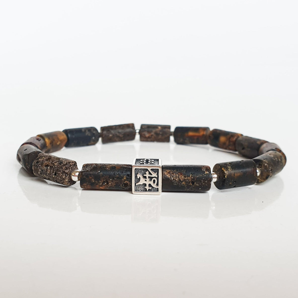 Bracelet with brown Baltic amber beads and a silver Vytis on a white background