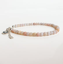 Load image into Gallery viewer, Beaded bracelet with a silver charm on a light background