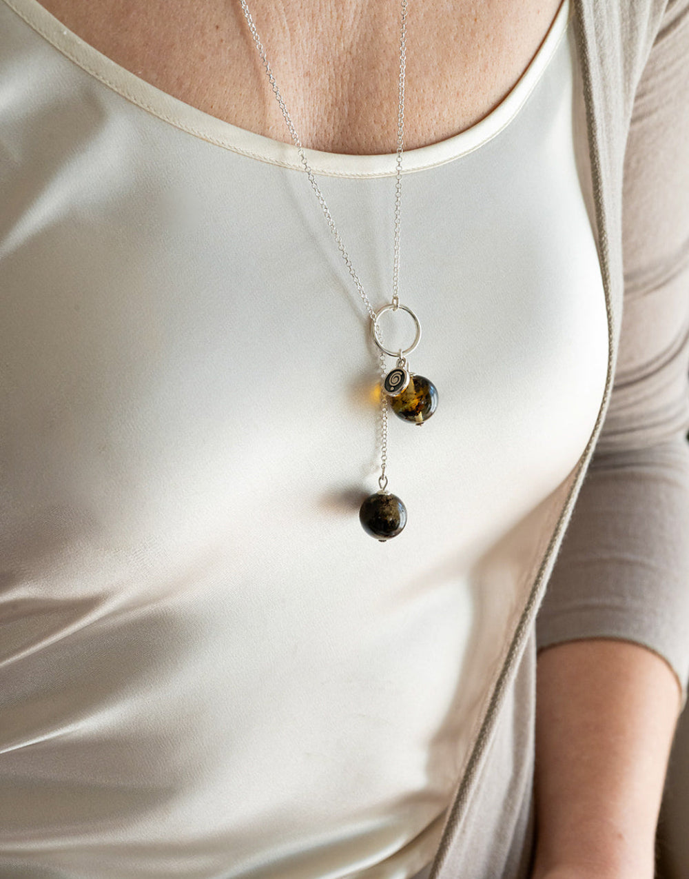 Necklace with amber beads worn by a person in a white tank top