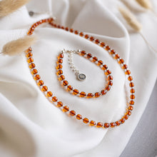 Load image into Gallery viewer, Beaded necklace and bracelet on a white fabric background