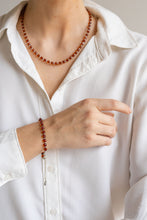 Load image into Gallery viewer, Person wearing a white shirt with a beaded amber necklace and bracelet, pointing to the jewelry.