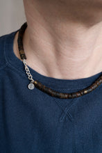 Load image into Gallery viewer, Person wearing a dark amber  beaded necklace with a blue shirt