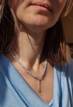 Load image into Gallery viewer, A beaded necklace with light blue aquamarine stones and a handmade silver medallion with a spiral design.