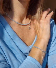 Load image into Gallery viewer, A beaded necklace with light blue aquamarine stones and a handmade silver medallion with a spiral design.